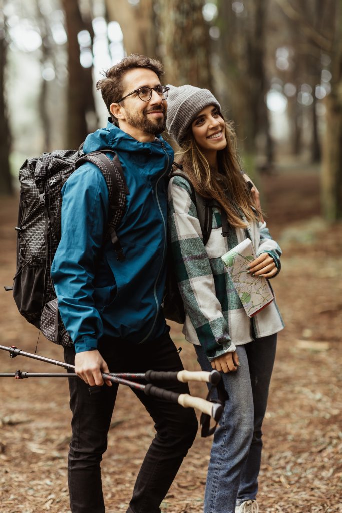 Pareja haciendo trekking con mochila y bastones